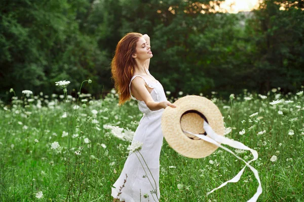 Glad kvinna i ett fält utomhus blommor frisk luft frihet — Stockfoto