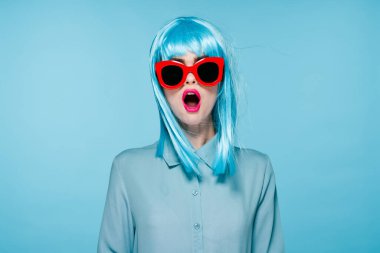 Neşeli kadın mor peruk gözlüğü el hareketi mavi arka plan