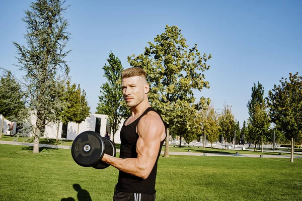 Sportowy mężczyzna w czarnej koszulce w parku trening styl życia — Zdjęcie stockowe