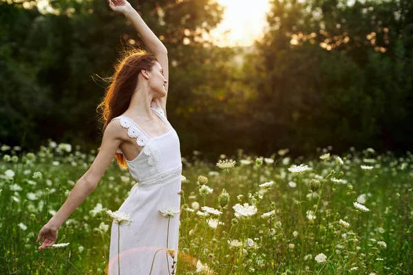 Femme en robe blanche dans un champ fleurs soleil nature liberté — Photo