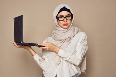 Laptop öğrenme teknolojisi olan Müslüman kadın.
