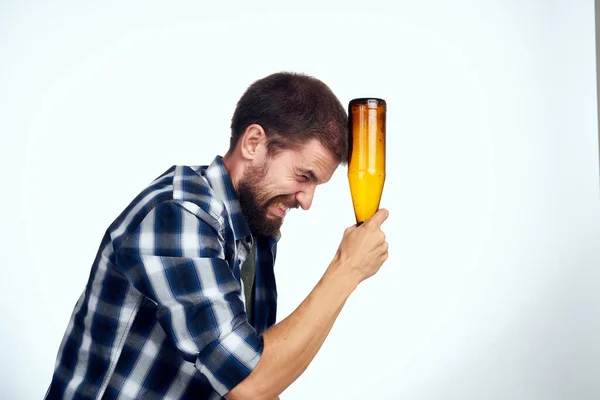 Um homem em uma camisa xadrez cerveja álcool emoções diversão luz fundo — Fotografia de Stock