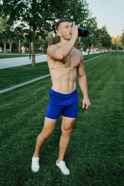 Parktaki sporcu kaslı adam sağlıklı gıda zindeliği — Stok fotoğraf