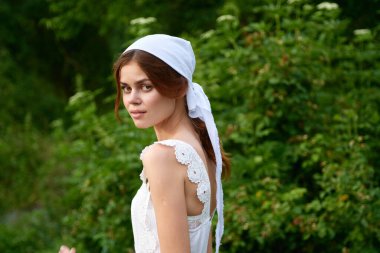 Köyde beyaz elbiseli bir kadın var. Yeşil çimen çiftçisi.