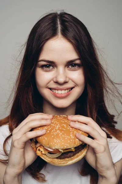 Femme avec un hamburger dans ses mains une collation fast food close-up — Photo