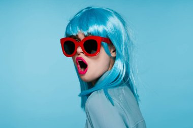 Mor peruklu, kırmızı gözlüklü çekici bir kadın. Yakından poz veriyor.