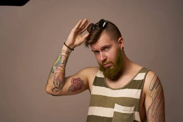Homem barbudo em listrado t-shirt óculos tatuagem em seus braços moda — Fotografia de Stock