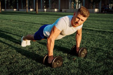 Parktaki adam yeşil çimen egzersiz egzersizi yapıyor.