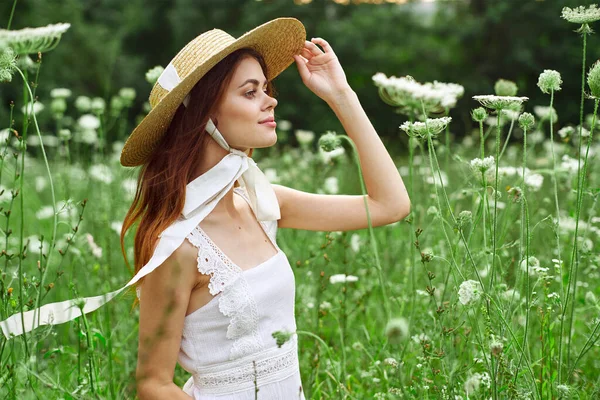 Kvinna med hatt vit klänning blommor natur avkoppling — Stockfoto