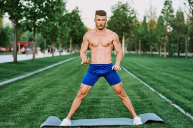 Sportif kaslı adam spor için parktaki spor motivasyonuna gidiyor.