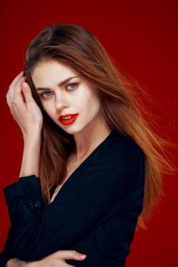 Kırmızı dudaklı güzel kadın kızıl saçlı Glamor kırmızı arka planda poz veriyor