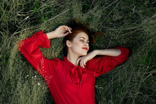 Femme en robe rouge se trouve sur l'herbe nature liberté été — Photo