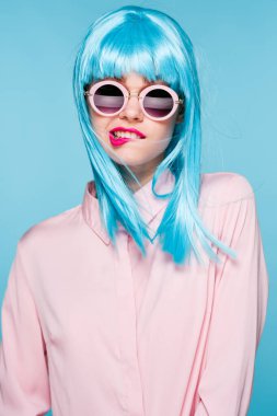 Mavi peruklu güzel kadın güneş gözlüğü takıyor.