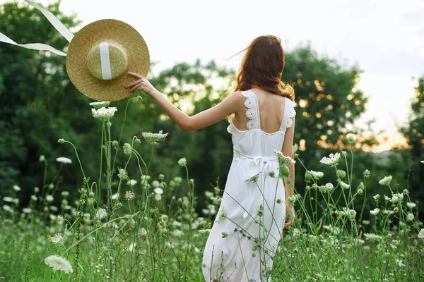Γυναίκα σε λευκό φόρεμα λουλούδια ελευθερία περπατήσει καθαρό αέρα — Φωτογραφία Αρχείου