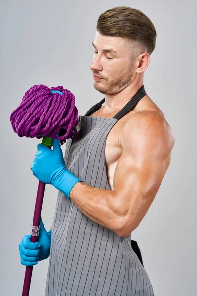 Mann in Schürze mit Wischmopp in der Hand posiert für Hausarbeit — Stockfoto
