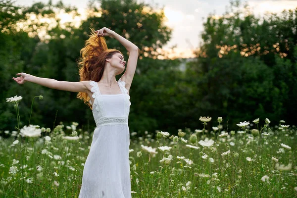 Mujer en vestido blanco en un campo flores sol naturaleza libertad — Foto de Stock
