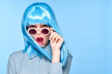 Neşeli kadın güneş gözlüğü takıyor mavi peruk cazibe modeli