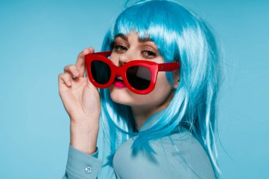 Mor peruklu, kırmızı gözlüklü çekici bir kadın. Yakından poz veriyor.