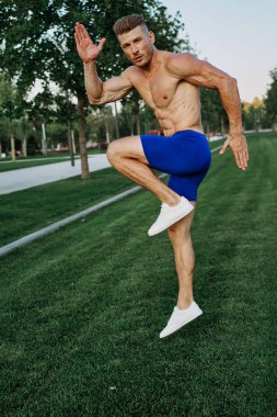 Parkta vücut egzersizi yapan atletik bir adam.