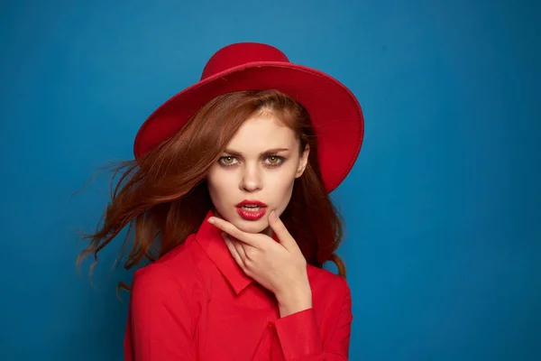 Mulher alegre olhar atraente posando chapéu vermelho fundo azul — Fotografia de Stock