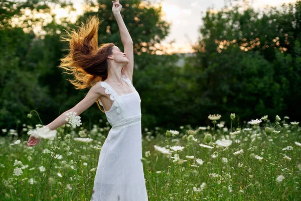 Kvinna i vit klänning i ett fält blommor sol natur frihet — Stockfoto