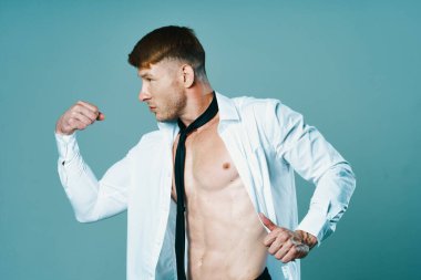 Düğmesiz gömlekli, kravatlı, kaslı bir adam.