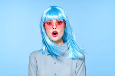 Pembe gözlüklü, mor peruklu neşeli kadın.