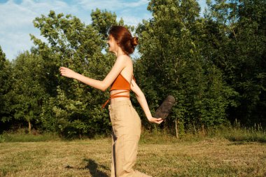 Dışarıda büyük siyah bir köpekle oynayan bir kadın. Eğlenceli bir arkadaşlık.