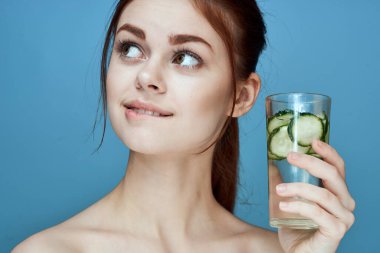 Salatalıklı güzel bir kadın sağlık vitaminleri içer.