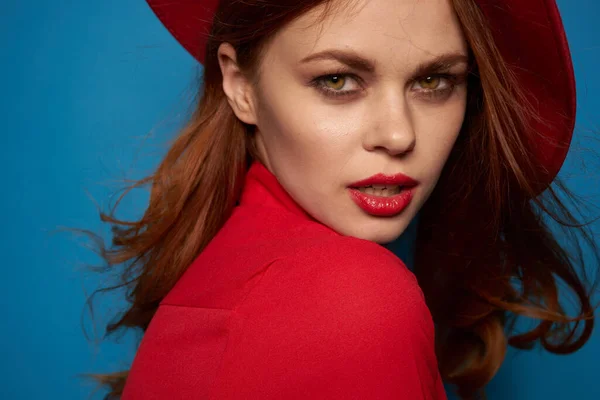 Bela mulher vestindo um chapéu vermelho cosméticos posando fundo azul — Fotografia de Stock