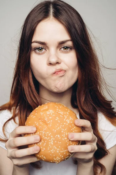 Femme avec un hamburger dans ses mains une collation fast food close-up — Photo