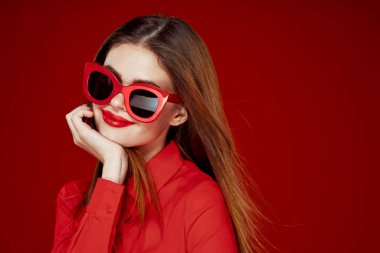 Kırmızı tişörtlü neşeli kadın. Güneş gözlüklü. Yakın plan.