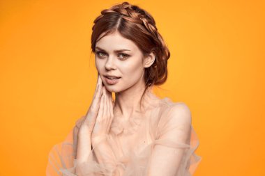 Bej elbiseli güzel bir kadın cazibesini dışa vuruyor.