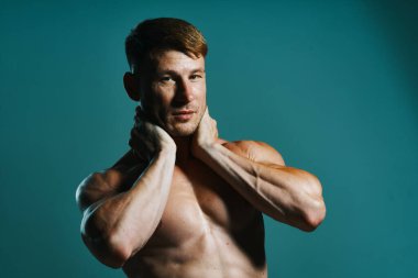 Vücudu kaslı, yeşil arka planı olan atletik bir adam.