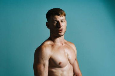 Şişkin üstsüz erkek vücut geliştirici pozu veren kas egzersizi yapıyor.