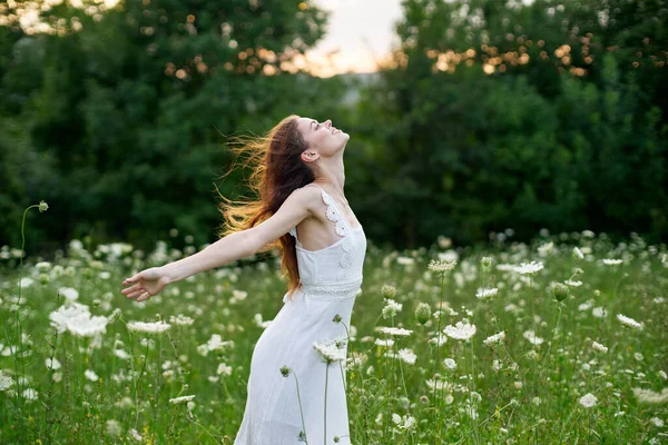 Femme en robe blanche dans un champ de fleurs marcher la liberté — Photo