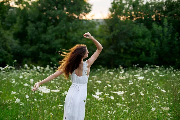 Kobieta w białej sukience w polu na łonie natury kwiaty wolność lato — Zdjęcie stockowe