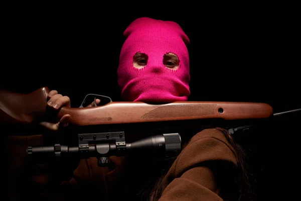 빨간 마스크를 쓰고 총기 범죄 조직 갱스터의 어두운 배경을 위협하는 여성 — 스톡 사진