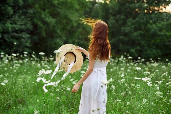 Vacker kvinna i ett fält i naturen vit klänning frisk luft — Stockfoto
