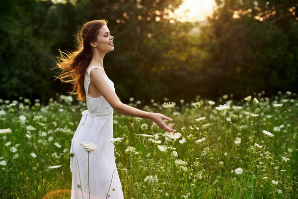 Femme en robe blanche dans un champ fleurs soleil nature liberté — Photo