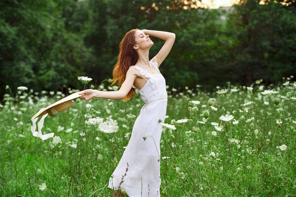 Cheerful woman in a field outdoors flowers fresh air freedom. High quality photo