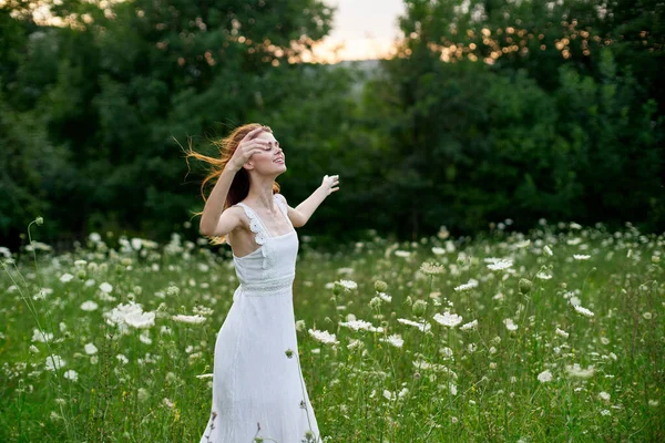 La mujer en el vestido blanco en el campo sobre la naturaleza florece la libertad el verano — Foto de Stock