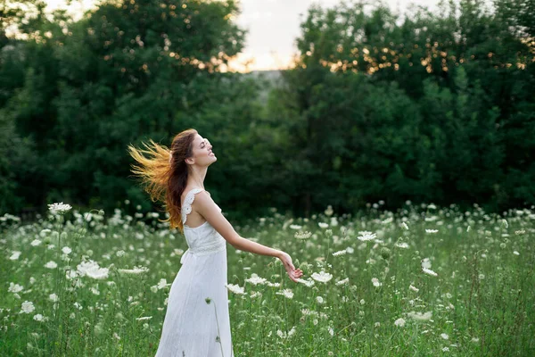 Žena v bílých šatech na poli na přírodě květiny svoboda léto — Stock fotografie