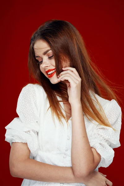 Allegra donna dai capelli rossi con labbra rosse vestito bianco sfondo rosso — Foto Stock