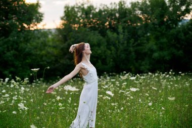 Beyaz elbiseli kadın dans doğası yaz pozu veriyor.