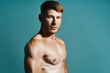 Vücudu kaslı, yeşil arka planı olan atletik bir adam.