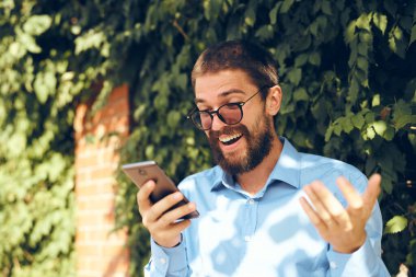 Yönetici sokak teknolojisiyle telefonda konuşuyor.