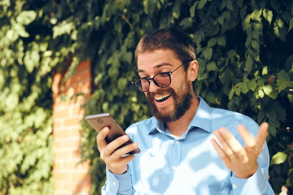Yönetici sokak teknolojisiyle telefonda konuşuyor.