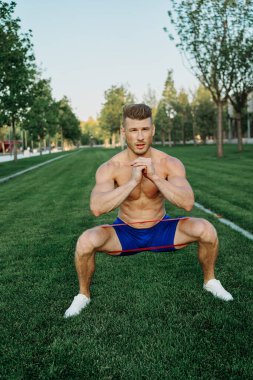 Atletik adam parkta koşma egzersizi yapıyor.