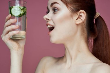 Salatalıklı güzel bir kadın vitamin içer. Sağlıklı güzellik.